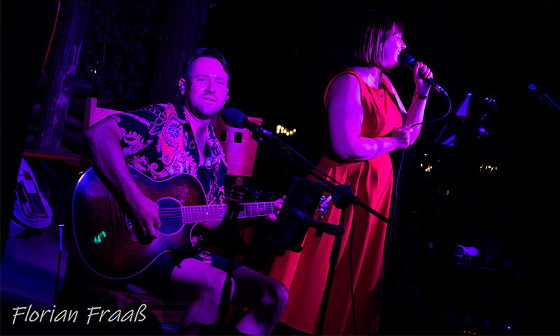 Jana und Danny mit Gitarre singend während Danny in die Kamera blickt